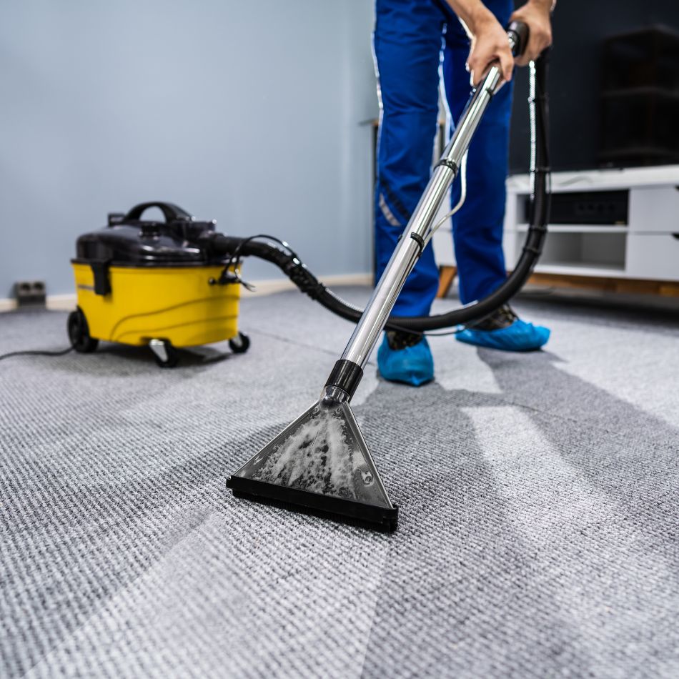 Close-up of professional steam rug cleaning removing dirt and stains from a patterned rug using extraction machine